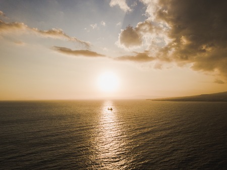 Silhouette of cargo ship at sunsetの写真素材
