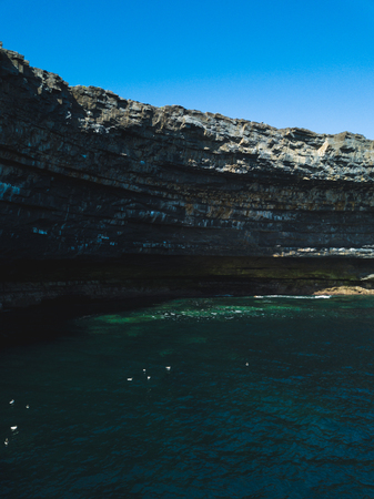 Beautiful view of the Inis Mór cliffs on a cloudy day. Taken from the top of the high cliff edge, showing the fields and ocean on a calm day.の写真素材