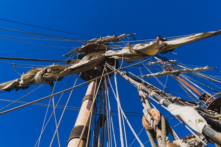 Sailors work with sails at a height on a traditional sailboatの写真素材