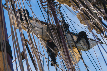 Sailors work with sails at a height on a traditional sailboatの写真素材
