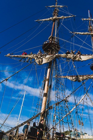 Sailors work with sails at a height on a traditional sailboatの写真素材