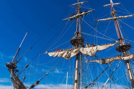 Sailors work with sails at a height on a traditional sailboatの写真素材