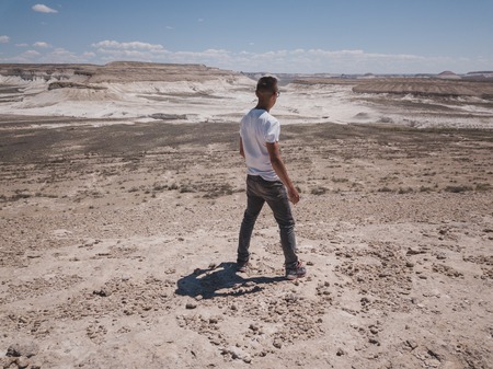 man looks into the distance in the deserts and mountains in Kazakhstan like from another planetの写真素材