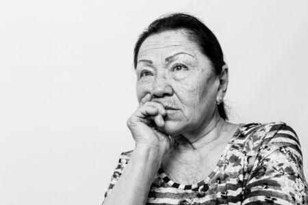 Portrait of elderly senior woman, black and white photo. Thinking about passed years. Loneliness, solitude.の写真素材