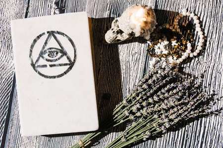 White magic book laying on the table with rosaries, lavender. Concept of fortune telling, ritual,...