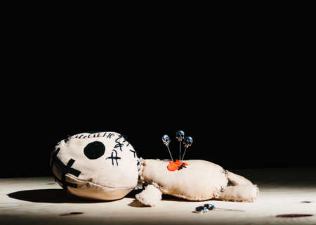 Pins with skulls stabbed in a voodoo doll for your magic ritual on a black backgroundの写真素材