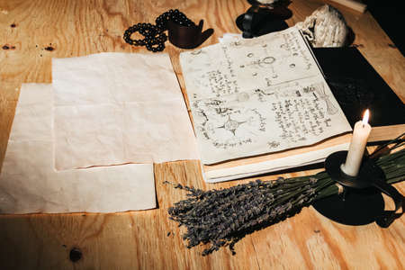 Occult ritual of white magic using grimoire, old book, candlesの写真素材
