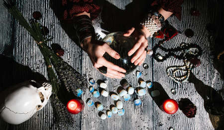 Fortuneteller's hands with stone runes, top view. Prediction of the future. Mystic interior. Occult...