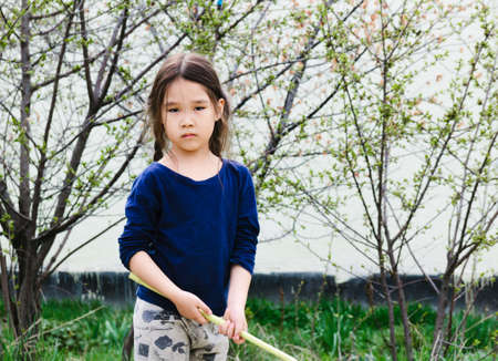 Portrait of an Asian girl in spring garden holding butterfly netの写真素材