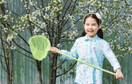Portrait of an Asian girl in spring garden holding butterfly netの写真素材