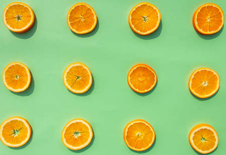 Bright, tasty, fresh, juicy orange slices on green background, natural vegan food, good for alphabet, vitamins for immune systemの写真素材
