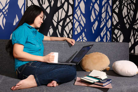 Work at home. Asian woman with her laptop doing her online businessの写真素材