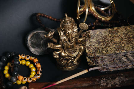 Table with occult attributes, top view. Ganesha figurine, stone rosaries, candles, aroma stickの写真素材