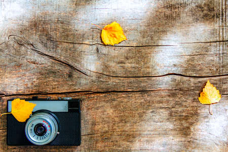 Photo camera on wood table. instant photo of retro camera - vintage and autumn fall season styleの写真素材