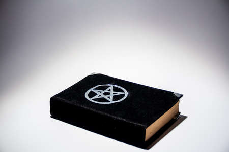 Occult grimoire, black magic book on the white background fortune telling, ritual, altar, spiritism,...