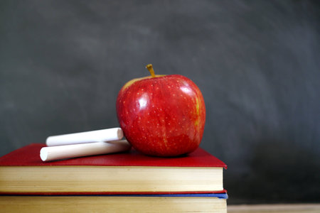 red apple and chalk on school booksの写真素材