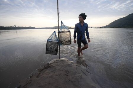 fisherman is walking on the river and wait for foodのeditorial素材