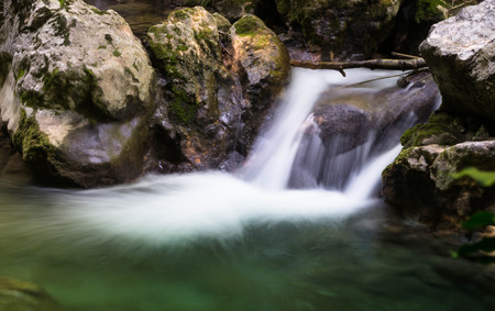 Cascade falls over mossy rocksの写真素材