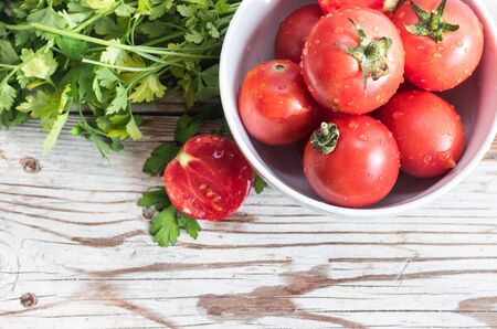 Fresh tomatos and herbs on wooden background. Summer salad. Summer backgroundの写真素材