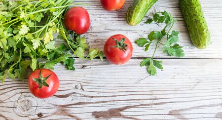 Fresh tomatos and cucumbers on wooden background. Summer salad.の写真素材