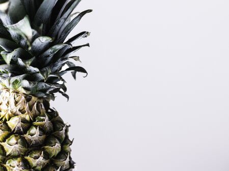 Ripe fresh pineapple closeup with leaves. Tropical background