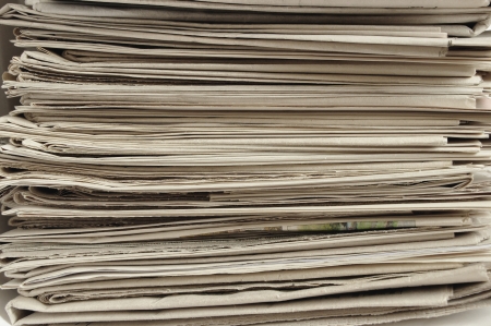 Many old newspapers stacked in a pile  