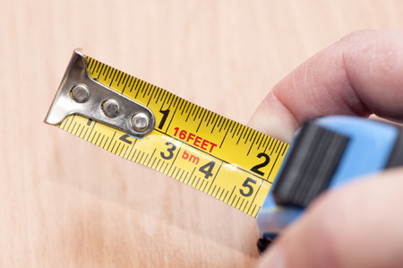 A metal tape measure with divisions in centimeters and feet.の写真素材