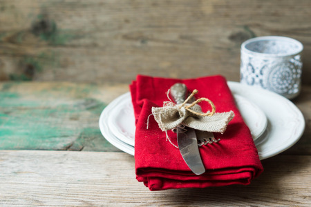 Table setting: plates, vintage fork, knife and spoon with napkin on rustic wooden table. Top view...