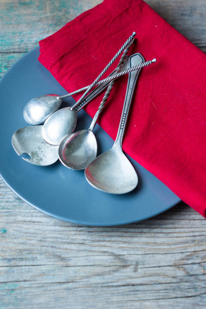 Table setting: plates, vintage fork, knife and spoon with napkin on rustic wooden table. Top view point.の写真素材