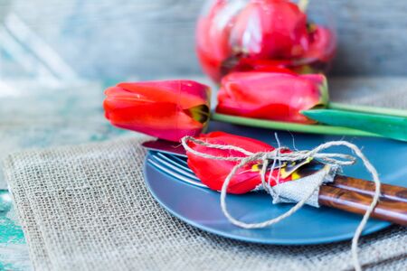 Red tulips with table set on a napkins, rusticの写真素材