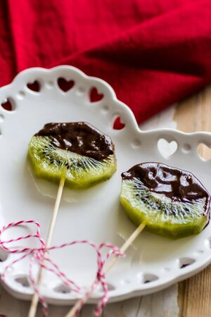 Kiwi with chocolate on a stickの写真素材