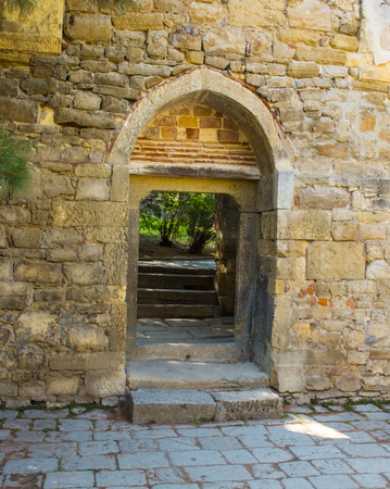 arched door on an old stone wallの写真素材