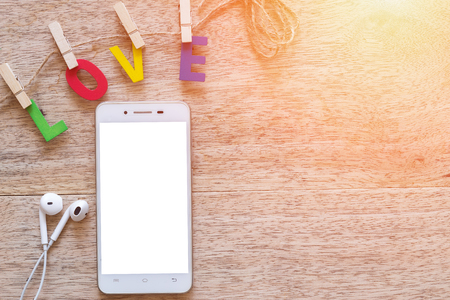 Smartphone with Valentine's day love Letter on wooden board background with copy space.の写真素材