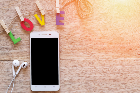 Smartphone with Valentine's day love Letter on wooden board background with copy space.の写真素材