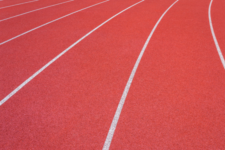 White lines of stadium and texture of running racetrack red rubber racetracks in outdoor stadium are 8 track and green grass fieldの写真素材