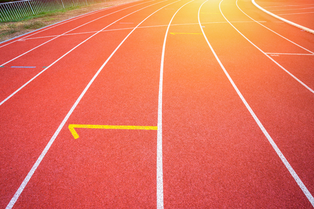 White lines of stadium and texture of running racetrack red rubber racetracks in outdoor stadium are 8 track and green grass fieldの写真素材
