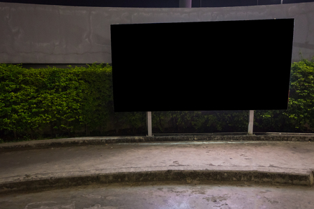 Blank billboard ready for new advertisement,lightbox mounted on the wall of store street in a city at night.の写真素材
