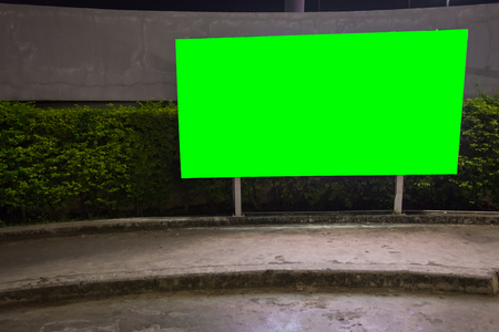 green screen blank billboard ready for new advertisement,lightbox mounted on the wall of store street in a city at night.の写真素材
