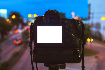 Close-up of DSLR Camera capturing on colorful light abstract circular bokeh background,Night time,Mockup image of with blank screen,DSLR on Tripod.の写真素材