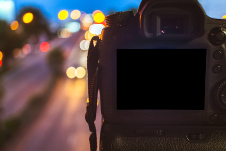 Close-up of DSLR Camera capturing on colorful light abstract circular bokeh background,Night time,Mockup image of with blank screen,DSLR on Tripod.の写真素材