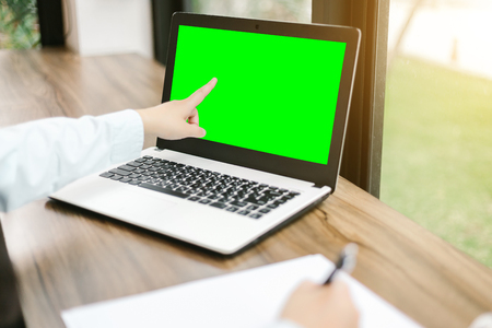 Close-up of business female working pointing at her laptop and make a note in coffee shop like the background,green screen.の写真素材