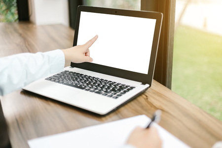 Close-up of business female working pointing at her laptop and make a note in coffee shop like the background.の写真素材