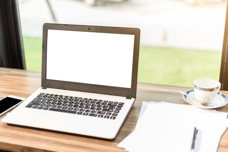 Mockup image of laptop with blank white screen,smartphone,coffee cup on wooden table of In the coffee shop.の写真素材
