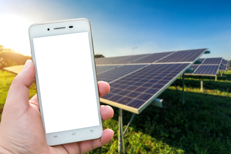 Men use smartphone blurred images in the solar panel background. As Renewable Energy and clean energy.の写真素材