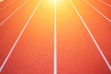 White lines of stadium and texture of running racetrack red rubber racetracks in outdoor stadium are 8 track and green grass fieldの写真素材