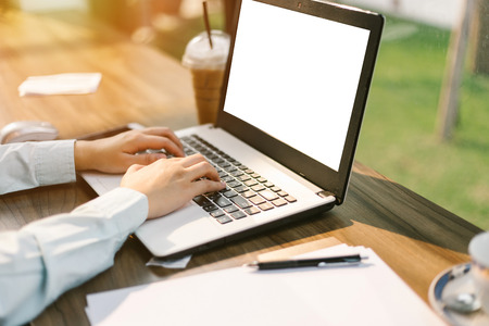Close-up of business female working with laptop make a note document and smartphone in coffee shop like the background.の写真素材