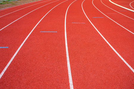 White lines of stadium and texture of running racetrack red rubber racetracks in outdoor stadium are 8 track and green grass field,empty athletics stadium with track,football field, soccer field.の写真素材