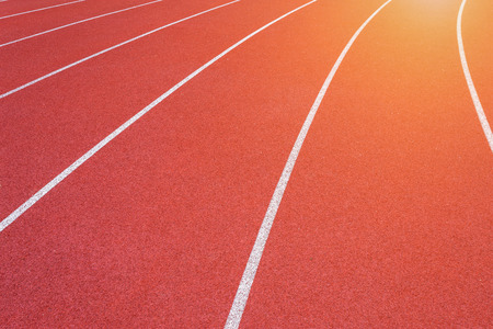 White lines of stadium and texture of running racetrack red rubber racetracks in outdoor stadium are 8 track and green grass field,empty athletics stadium with track.の写真素材