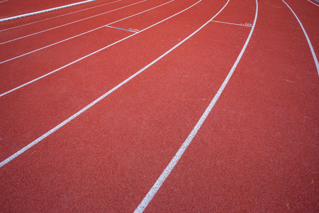 White lines of stadium and texture of running racetrack red rubber racetracks in outdoor stadium are 8 track and green grass field,empty athletics stadium with track.の写真素材