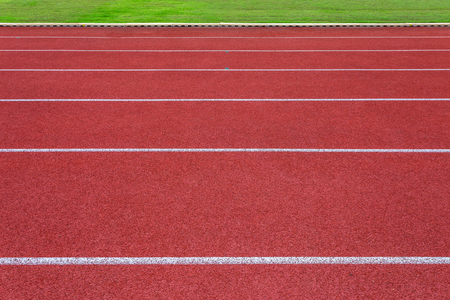 White lines of stadium and texture of running racetrack red rubber racetracks in outdoor stadium are 8 track and green grass field,empty athletics stadium with track.の写真素材